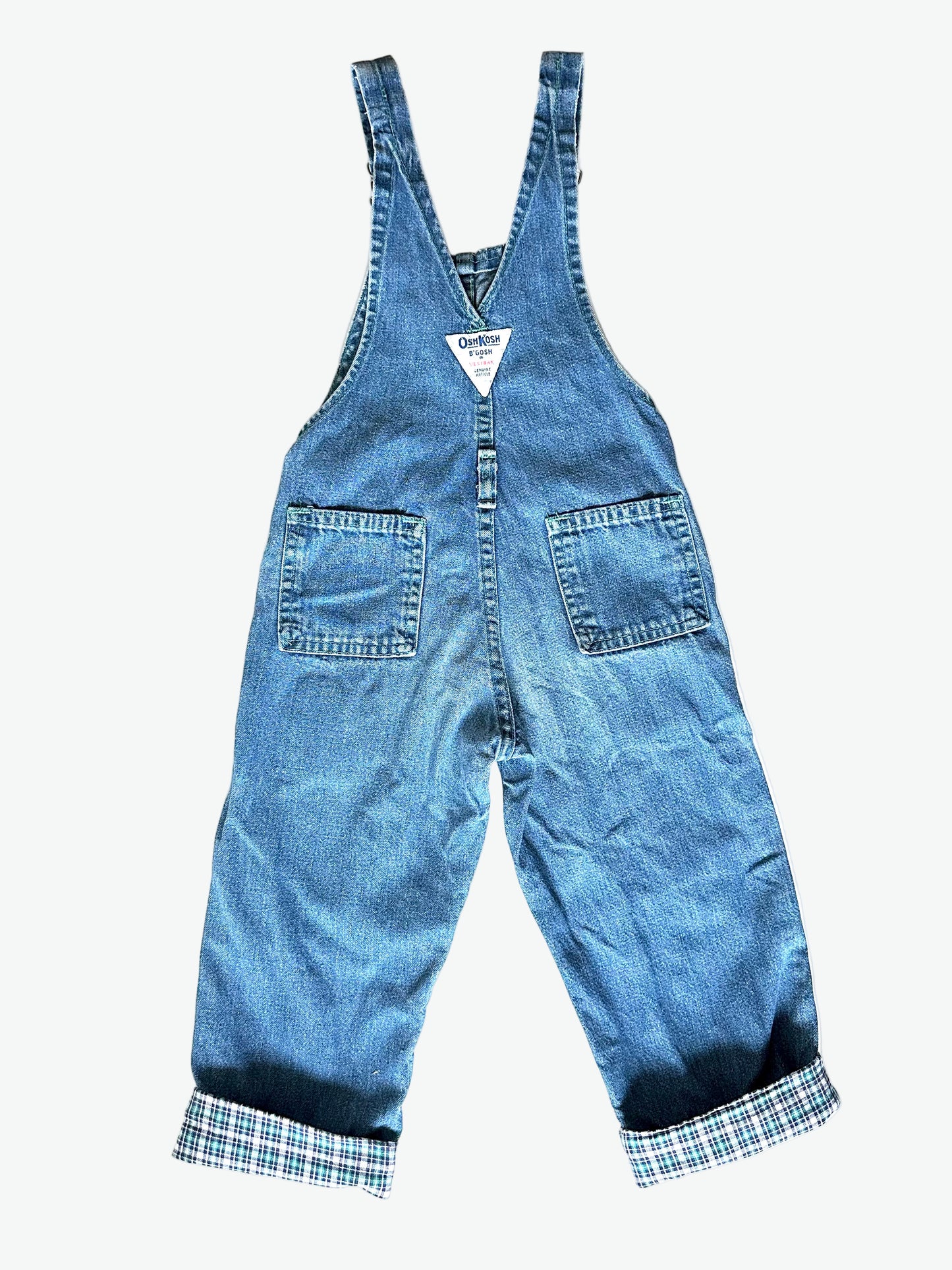 Kid vintage Oshkosh Blue denim dungarees with plaid cuffs and details on a white background