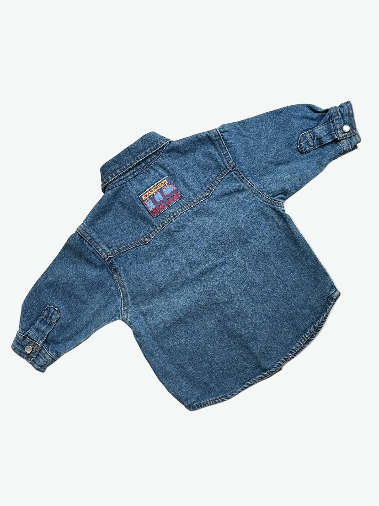Kids vintage denim shirt with classic western styling, pearlescent popper buttons, tan stitching and badge details. A classic in a mini size. Age 1 years.