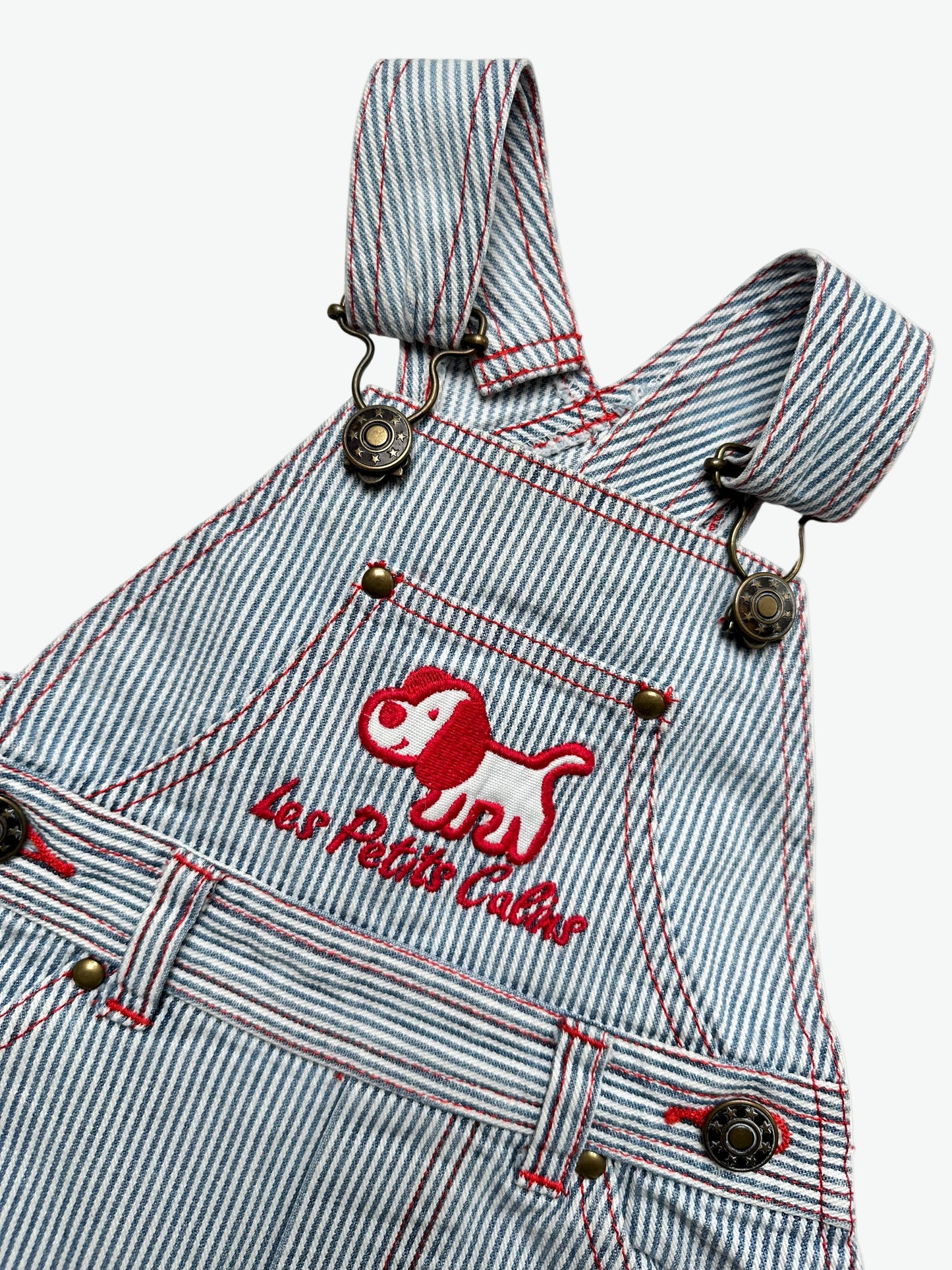 Kids vintage striped dungarees with contrast red stitching and a dog with the words'les petits calins'