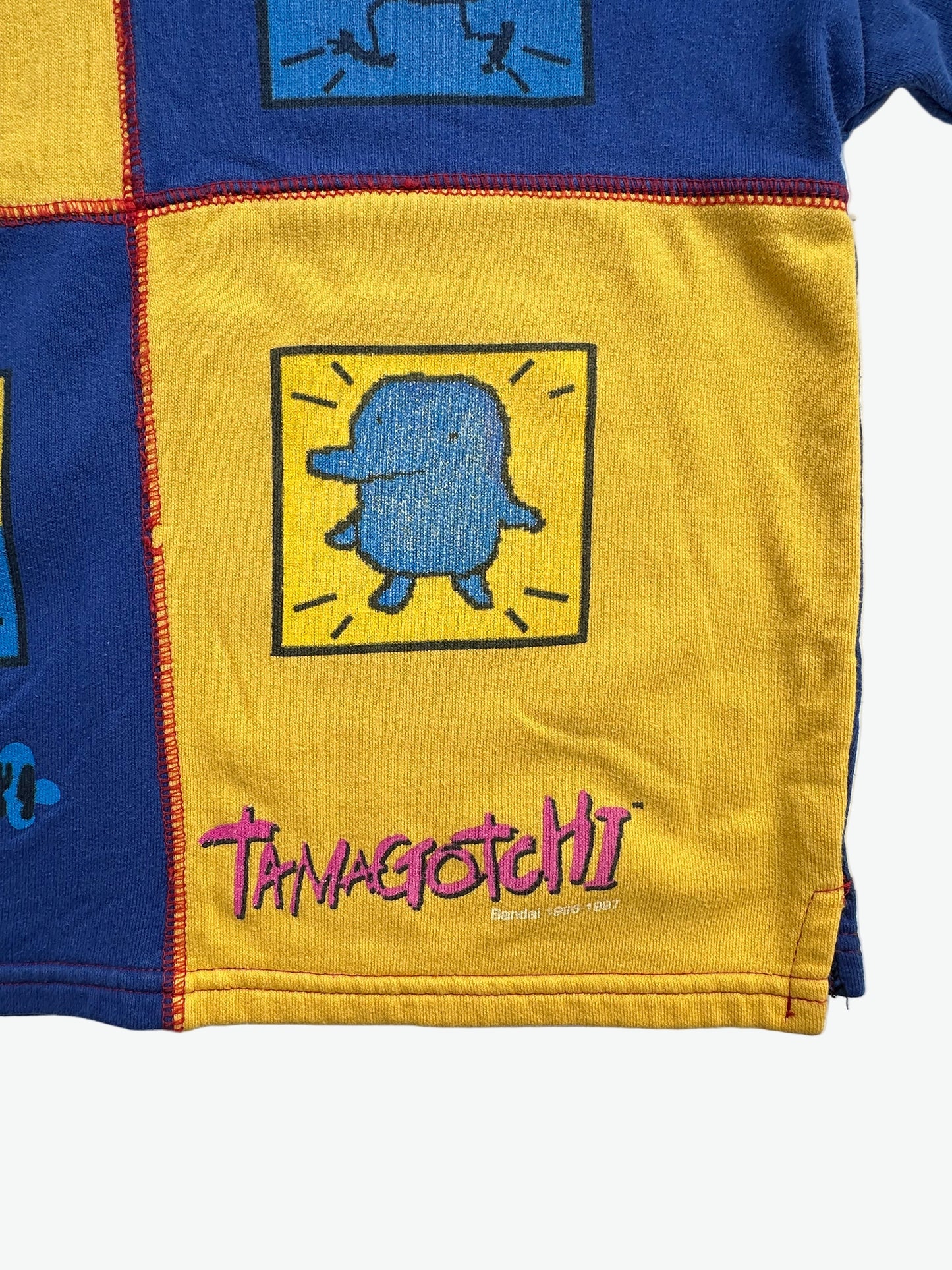 Kids vintage jumper branded Tamagotchi. Multi colour - red, blue and yellow, printed detail from 1996-1997. Age 10 years.