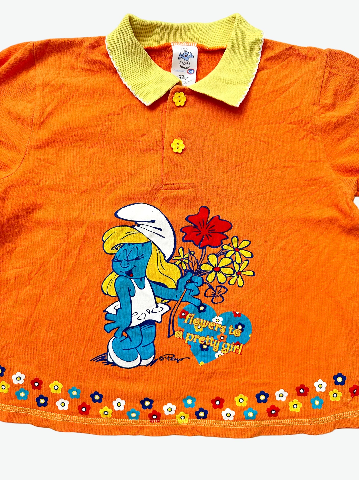 Kids vintage orange tshirt with a collar and flower buttons. Featuring a print of Smurfette and words saying flowers to a pretty girl.