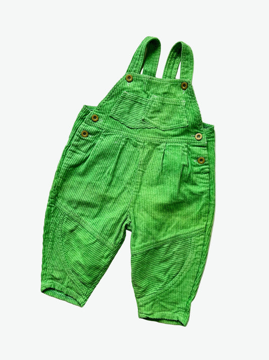 kids vintage bright green corduroy dungarees on a white background