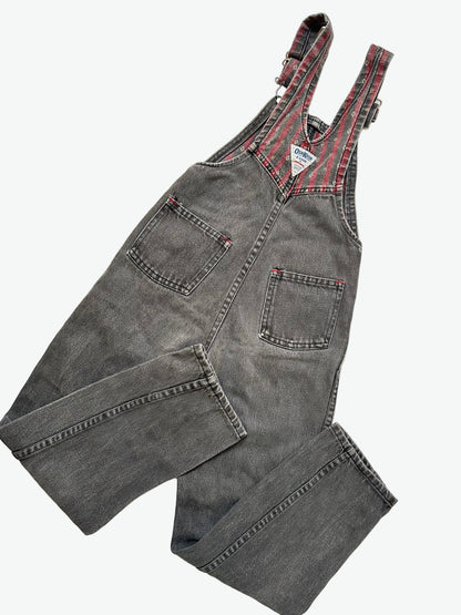 Kids vintage Gray and red denim dungarees with striped straps and Oshkosh brand label on a white background