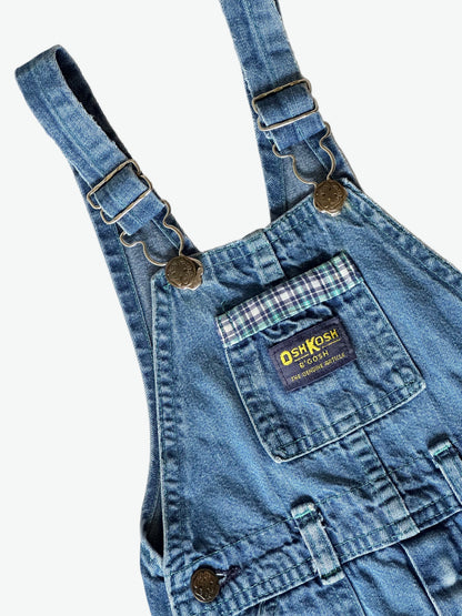 Kid vintage Oshkosh Blue denim dungarees with plaid cuffs and details on a white background
