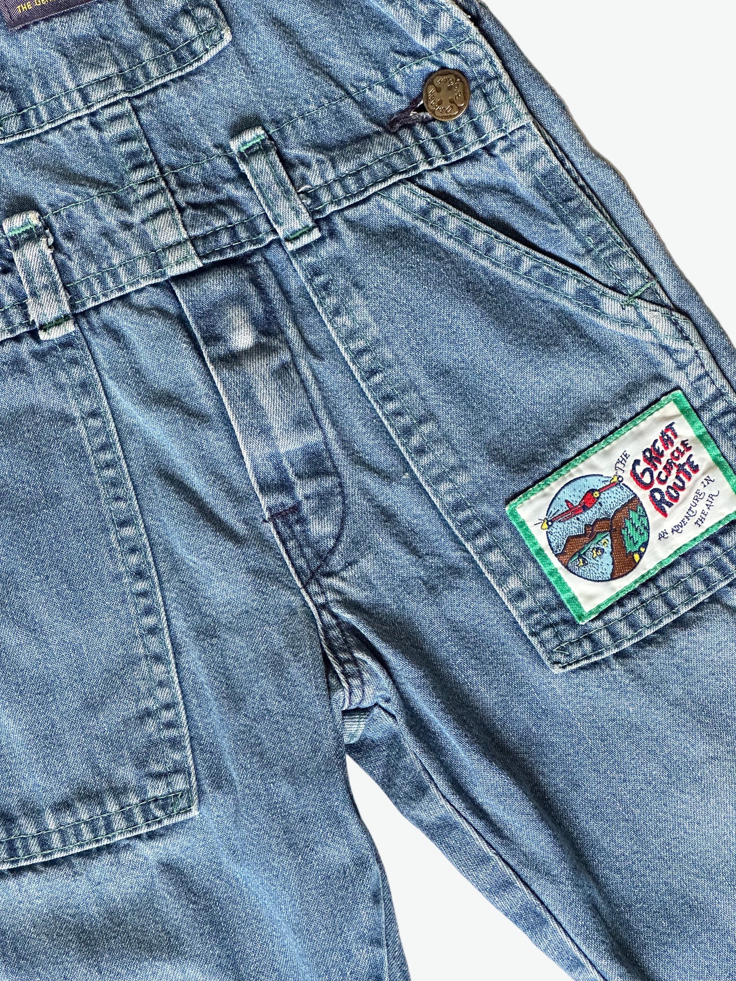 Kid vintage Oshkosh Blue denim dungarees with plaid cuffs and details on a white background