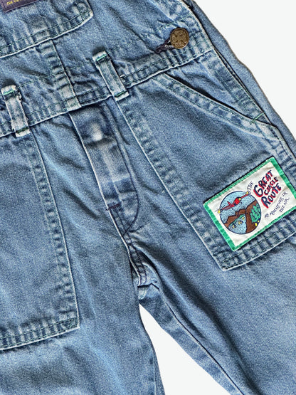 Kid vintage Oshkosh Blue denim dungarees with plaid cuffs and details on a white background