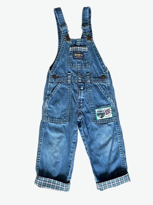 Kid vintage Oshkosh Blue denim dungarees with plaid cuffs and details on a white background