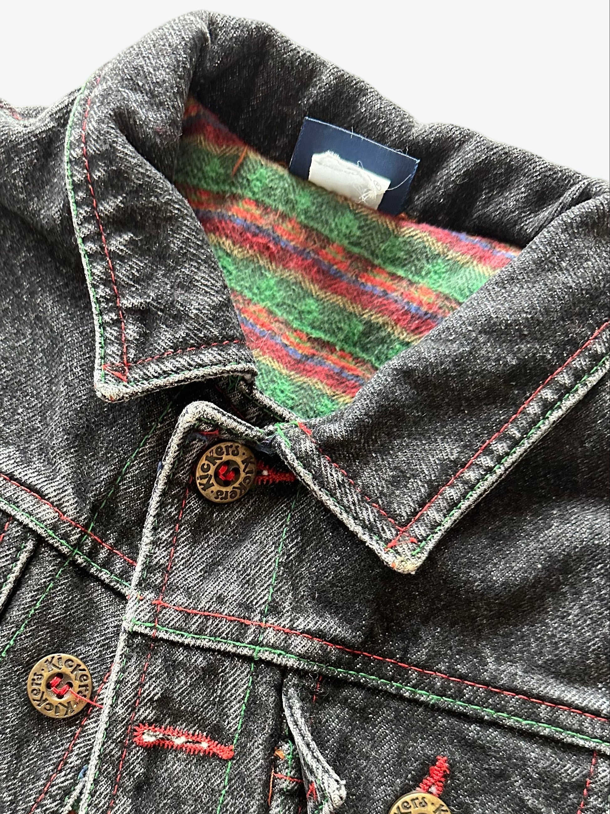 Kids vintage  faded black Denim jacket with red stitching, brass buttons and warm checkered lining on a white background