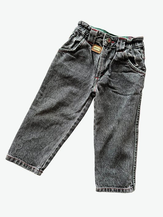 Kids vintage  faded black Denim jeans with red stitching highlights, brass buttons and unique badge details on a white background