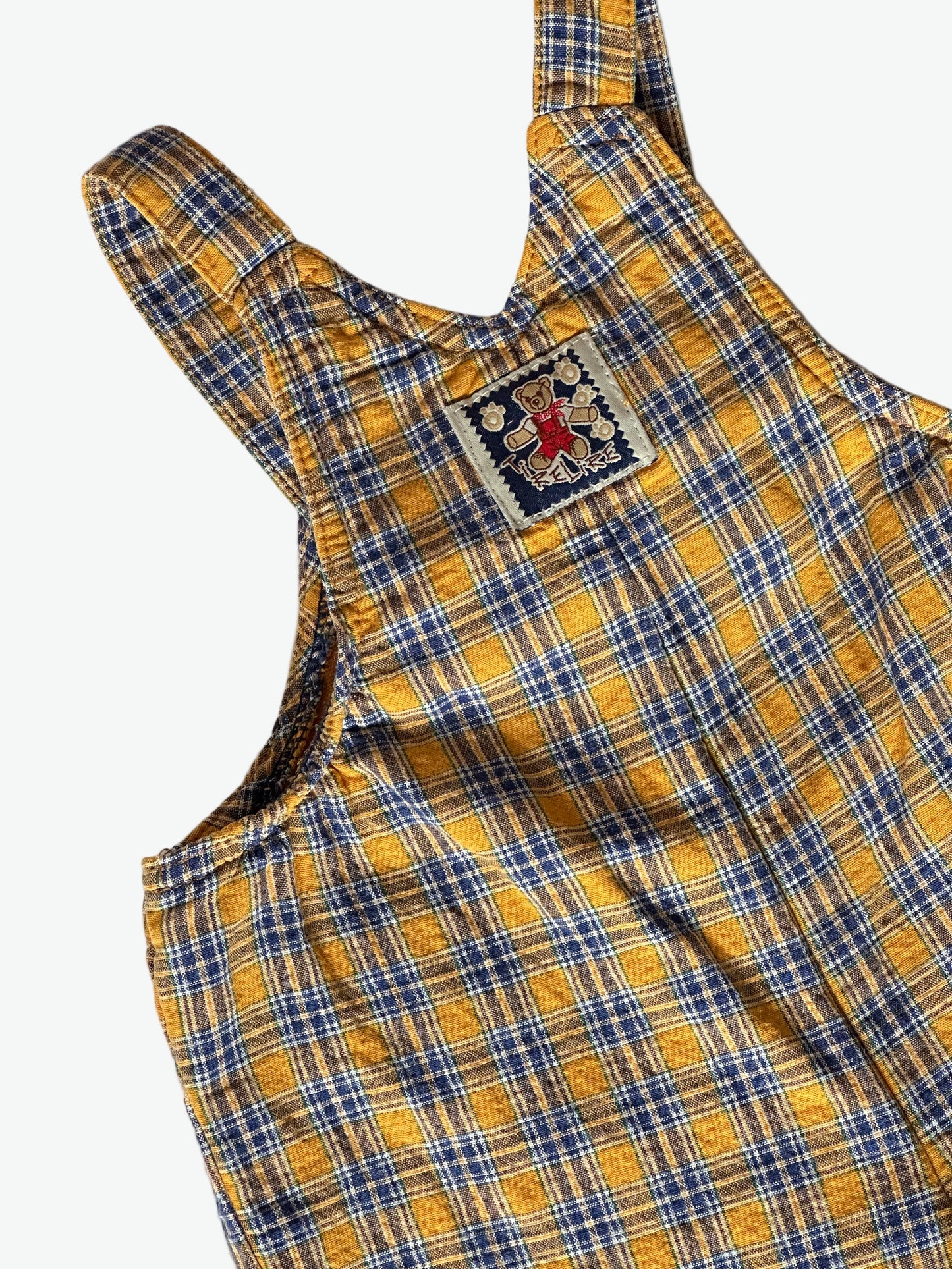 Yellow and blue check dungarees on a white background