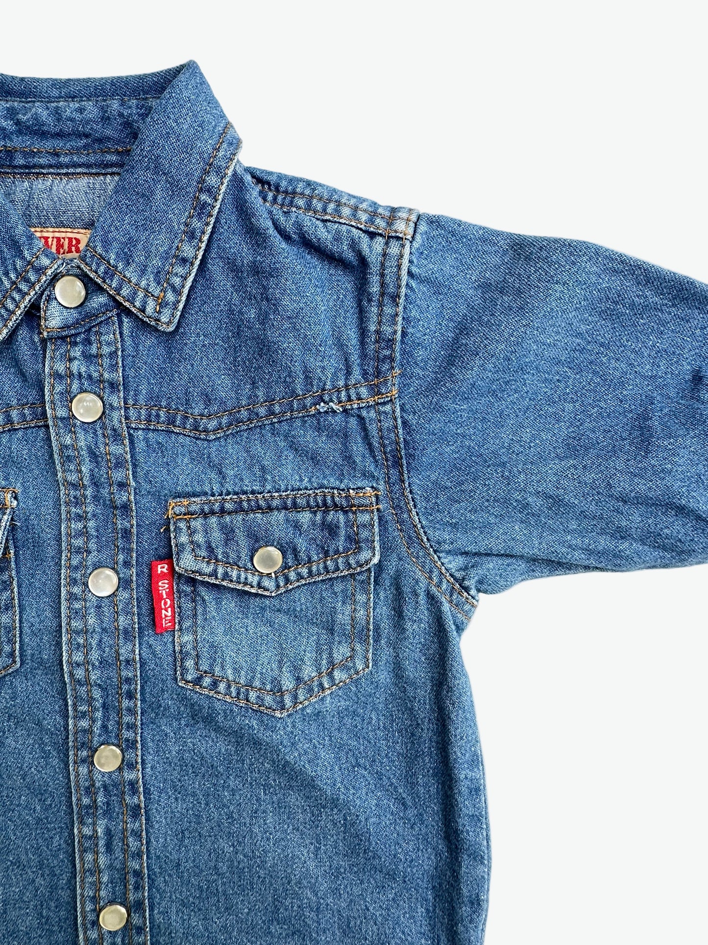 Kids vintage denim shirt with classic western styling, pearlescent popper buttons, tan stitching and badge details. A classic in a mini size. Age 1 years.