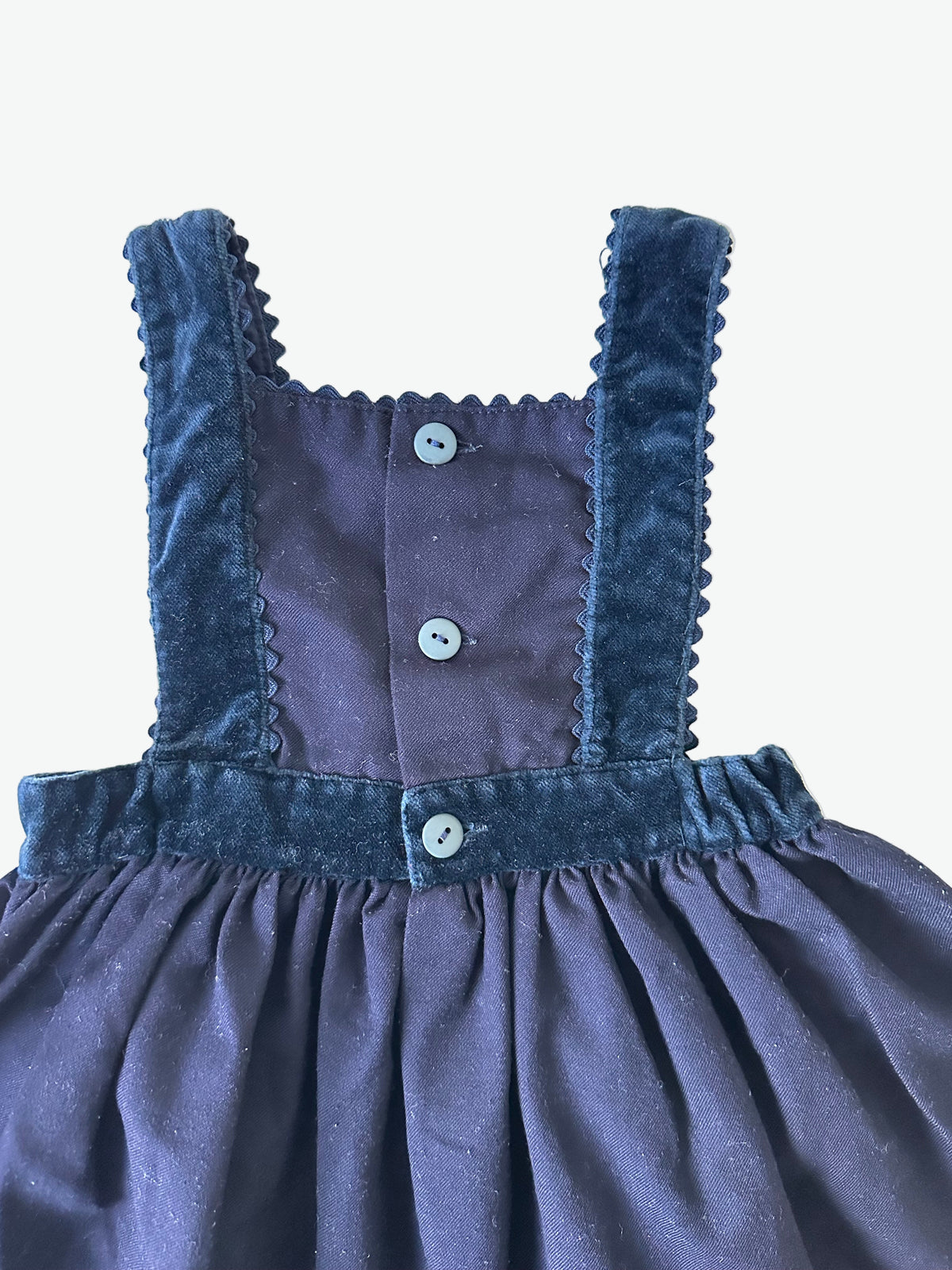 Navy blue dress with scallop trim edging on a white background