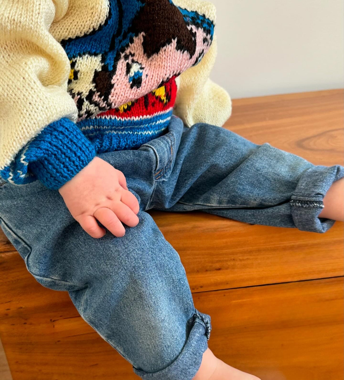 Kids vintage cream knitted jumper with the character knoddy and blue stripes at the hem and cuffs on a white background
