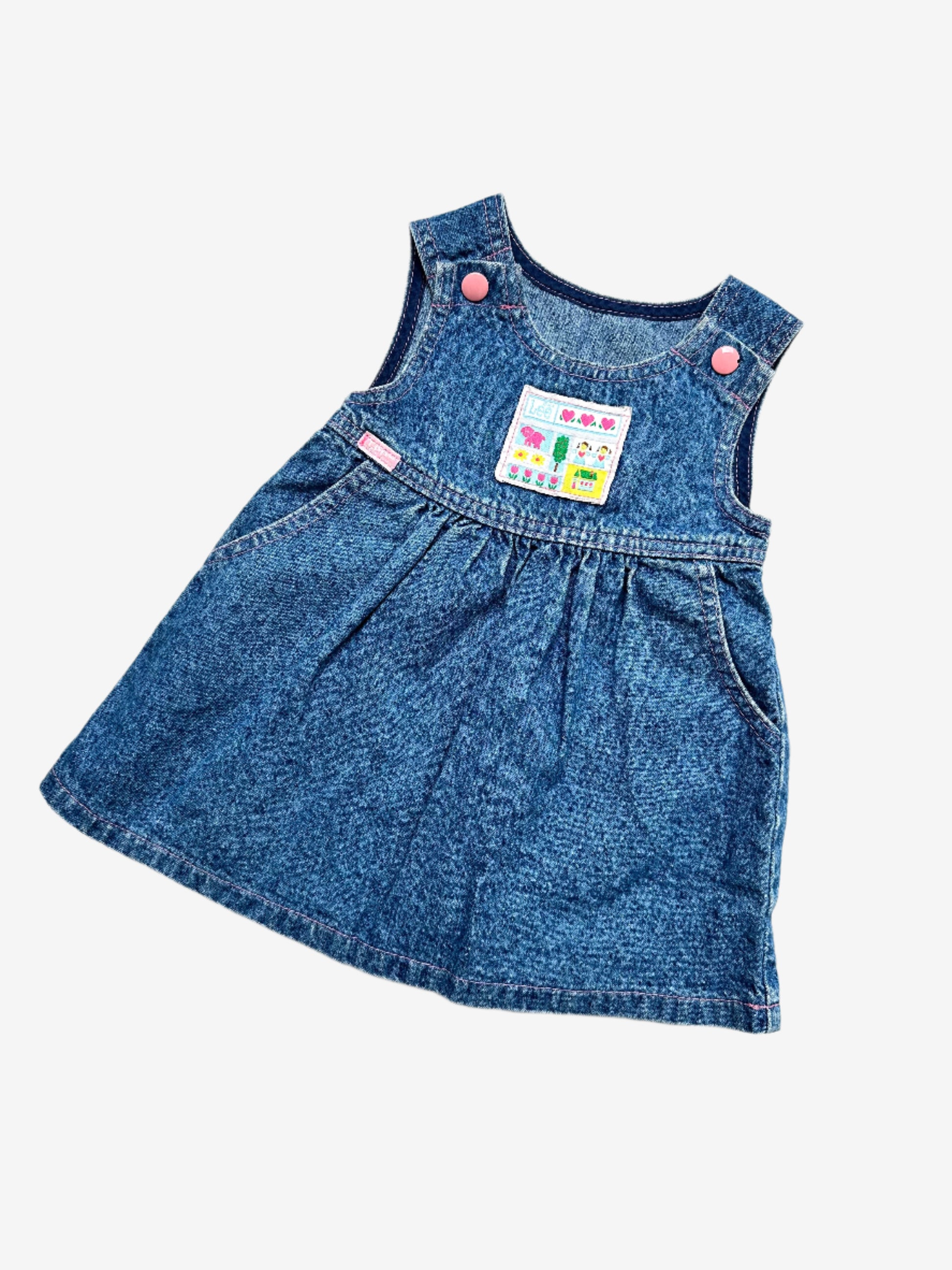 Kids Vintage acid wash dress from denim brand Lee, made in U.S.A, features an adorable chest badge featuring hearts, flowers, a tiny house, and a dog to the sweet pink enamelled popper fastenings on the straps. The A-line shape with gentle gathering at the waist makes it comfy and easy to wear. Age 2 years.