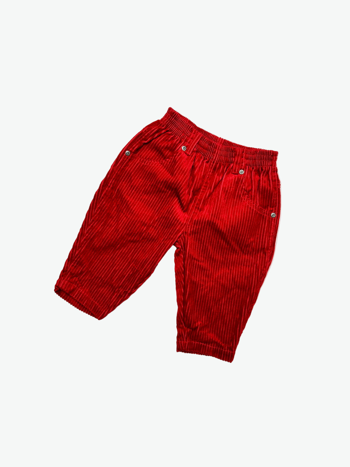 Red corduroy trousers on a white background