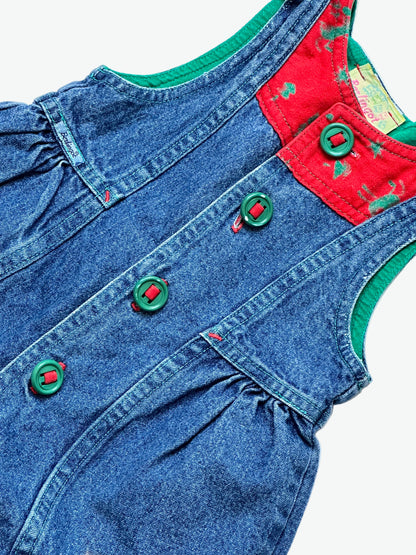 True blue denim romper with red patch detail with festive print and green buttons on a white background