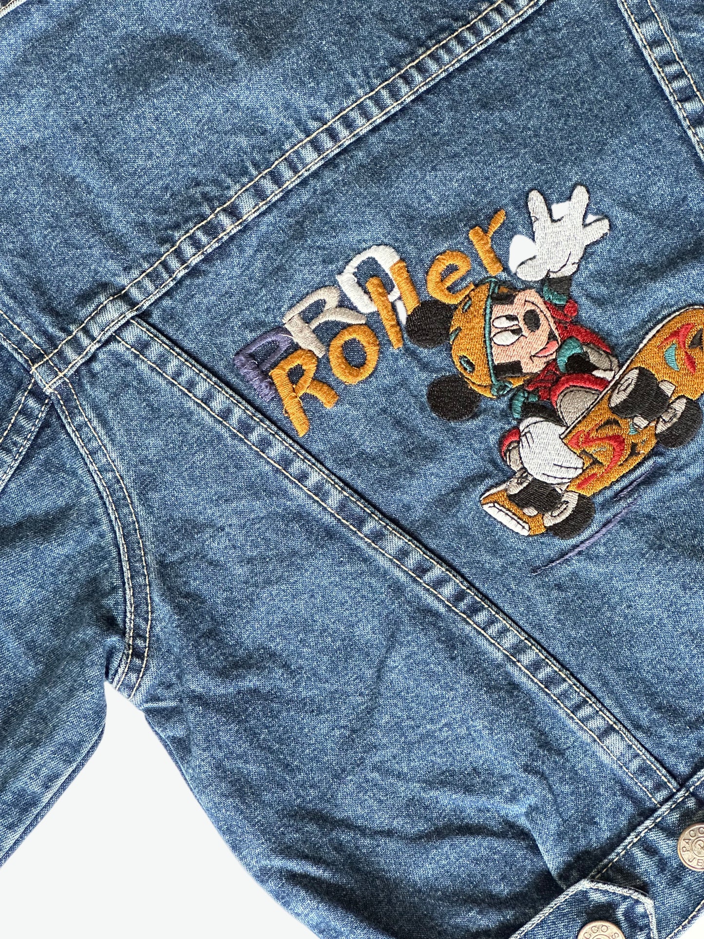 Kids vintage dark blue denim jacket with Mickey mouse on a skateboard embroidered design on the back on a white background